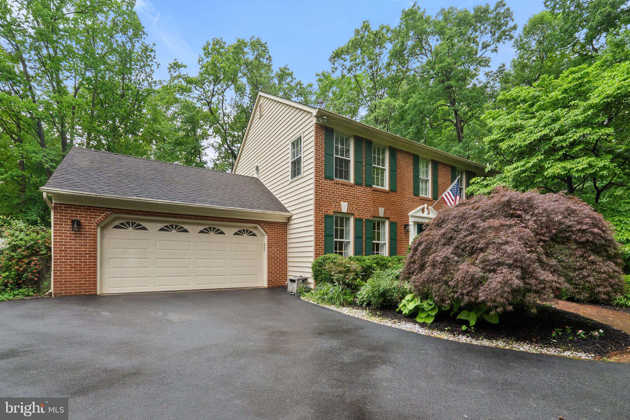 11100 Burywood Lane Reston, VA 20194 - Photo 2 of 42 a front view of a house with a yard and garage
