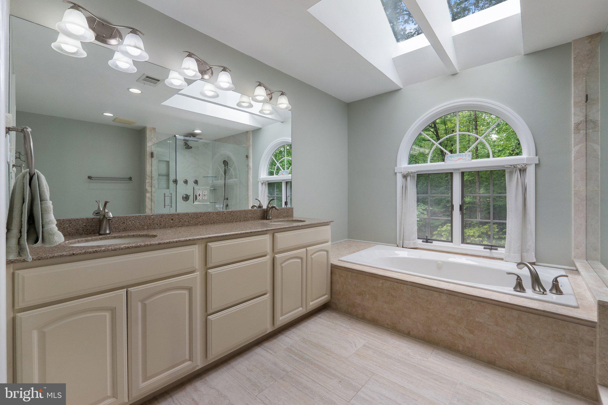 11100 Burywood Lane Reston, VA 20194 - Photo 26 of 42 a spacious bathroom with a granite countertop tub a sink and a large window