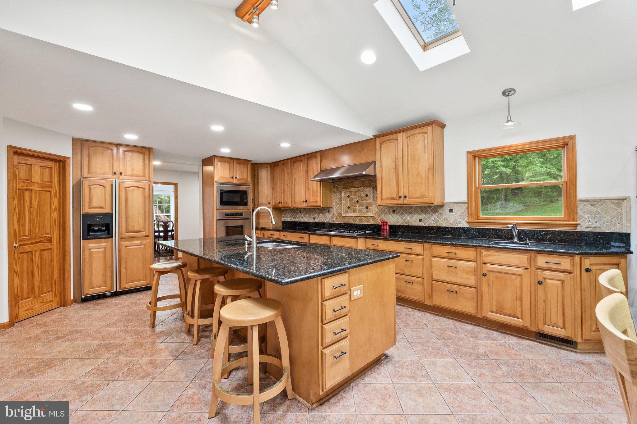 11100 Burywood Lane Reston, VA 20194 - Photo 9 of 42 a kitchen with stainless steel appliances granite countertop a stove top oven a sink dishwasher and a refrigerator with wooden floor