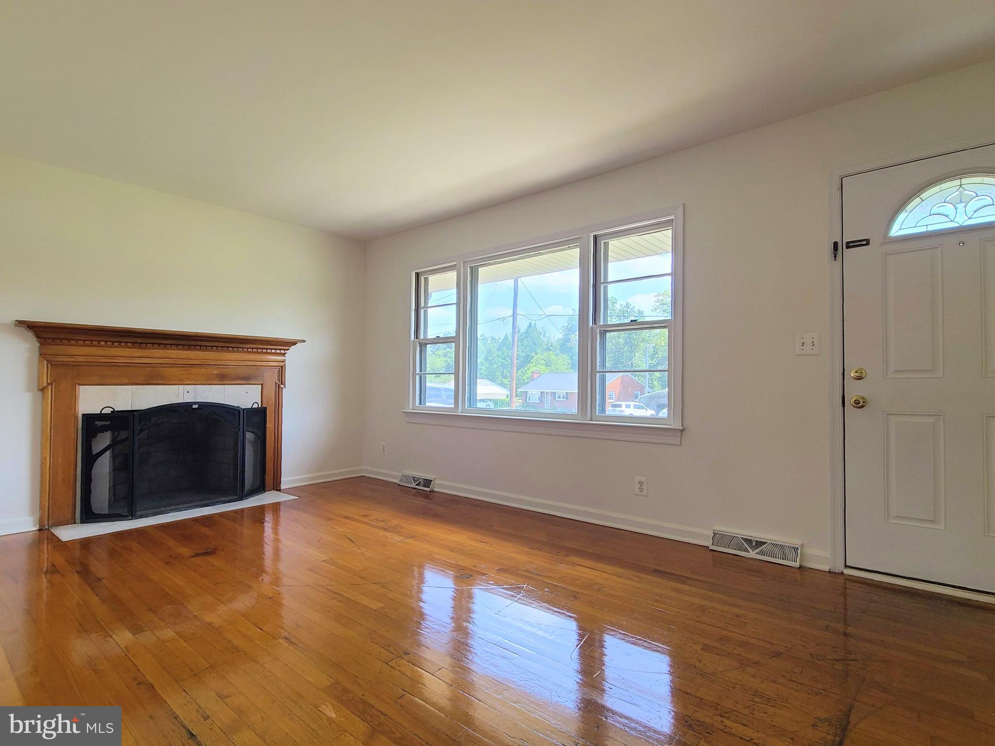 204 Mt Pleasant Boulevard Fredericksburg, VA 22405 - Photo 2 of 30 an empty room with wooden floor fireplace and windows