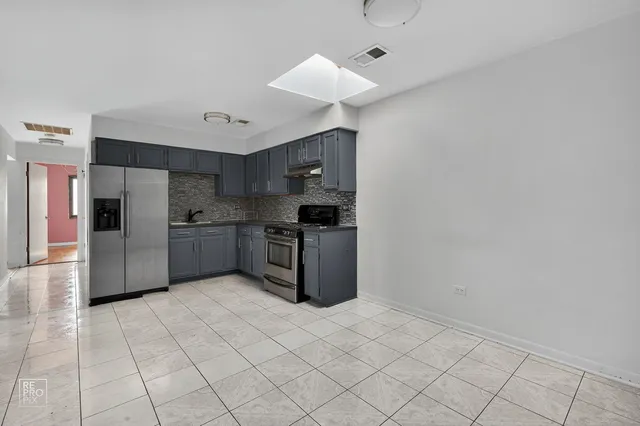 a kitchen with stainless steel appliances granite countertop a refrigerator and a sink