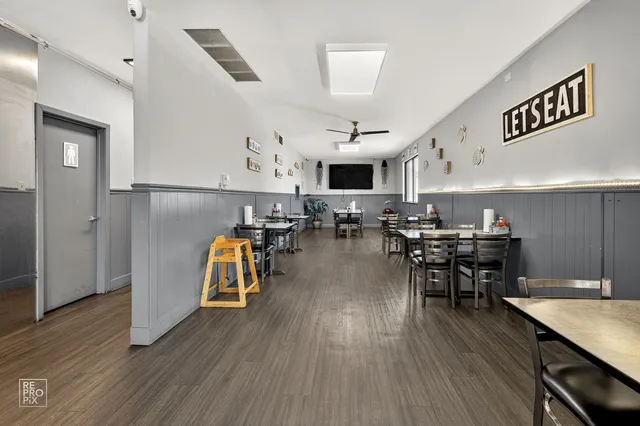 a kitchen with stainless steel appliances a dining table chairs stove and cabinets