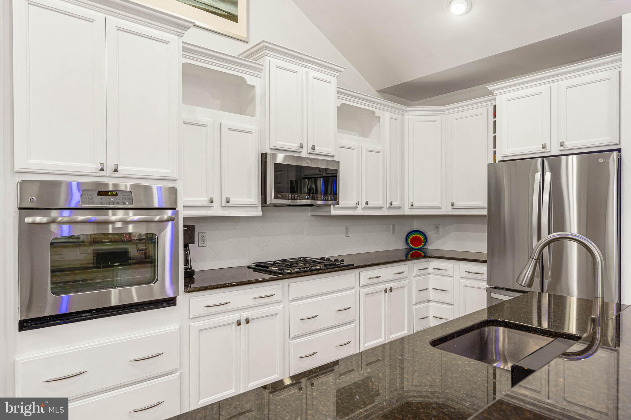 18923 Roth Drive Lewes, DE 19958 - Photo 23 of 73 a kitchen with granite countertop white cabinets and stainless steel appliances