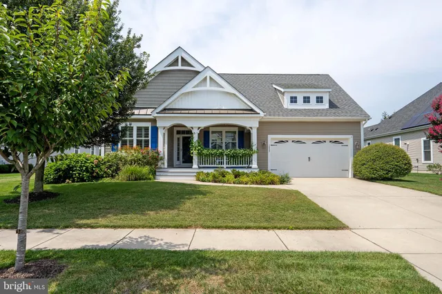 a view of a patio with couches and a table and chairs with wooden floor and fence
