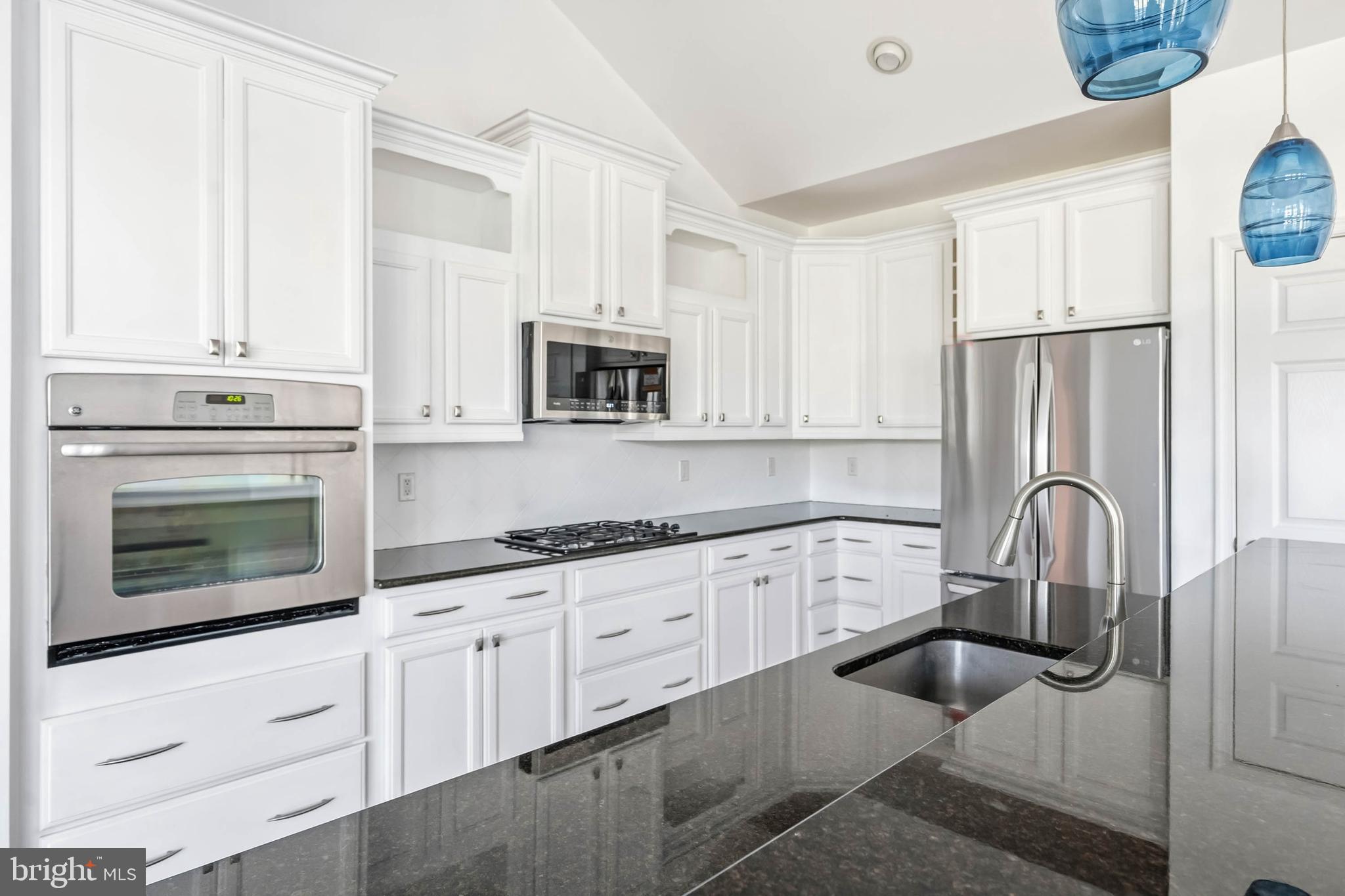 18923 Roth Drive Lewes, DE 19958 - Photo 58 of 73 a kitchen with granite countertop white cabinets and stainless steel appliances