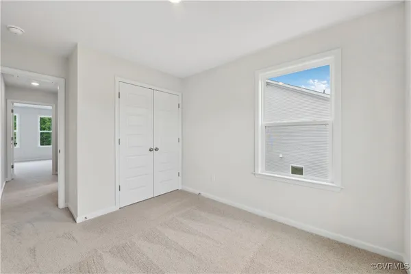 an empty room with windows and closet