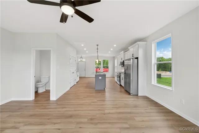 a view of a hallway with wooden floor and windows