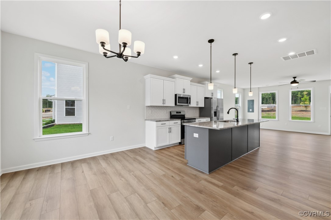 331 Mt Mccauley Way Aylett, VA 23009 - Photo 5 of 48 a large kitchen with stainless steel appliances granite countertop a stove a sink dishwasher a refrigerator and a dining table with wooden floor