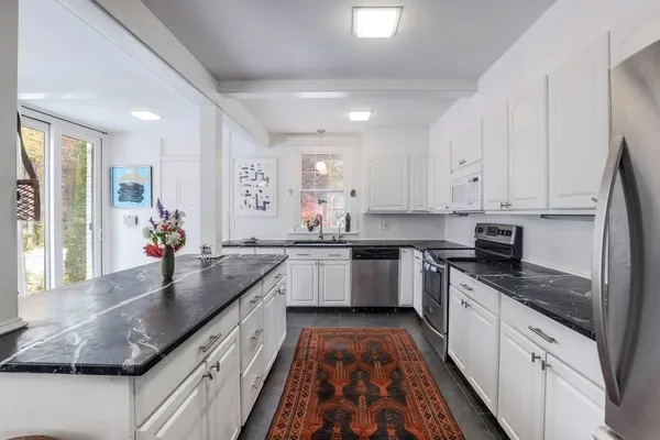 a kitchen with stainless steel appliances granite countertop a sink a stove and cabinets