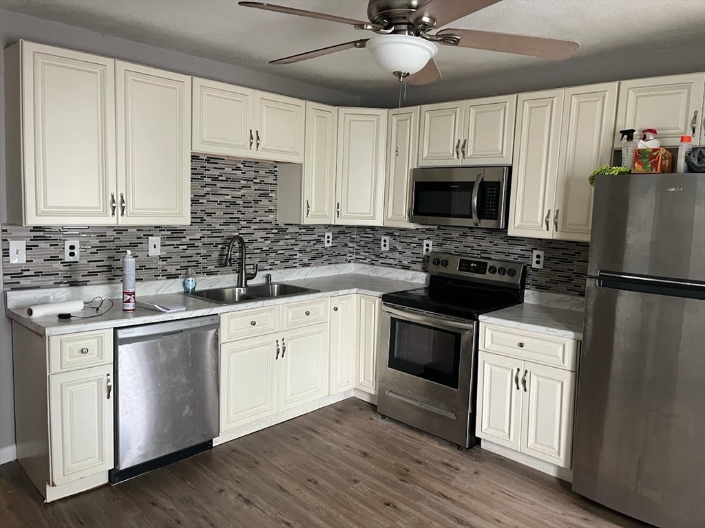 51 View Street Holyoke, MA 01040 - Photo 2 of 16 a kitchen with cabinets stainless steel appliances a sink and wooden floor