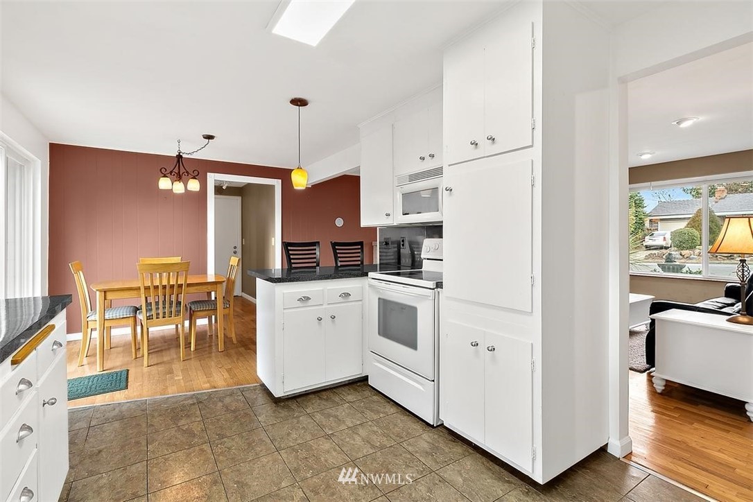 3407 Northeast 11th Street Renton, WA 98056 - Photo 12 of 27 a kitchen with white cabinets and stainless steel appliances