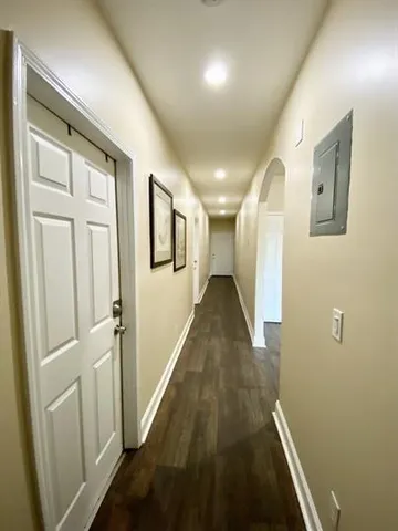 a view of a hallway with wooden floor and staircase