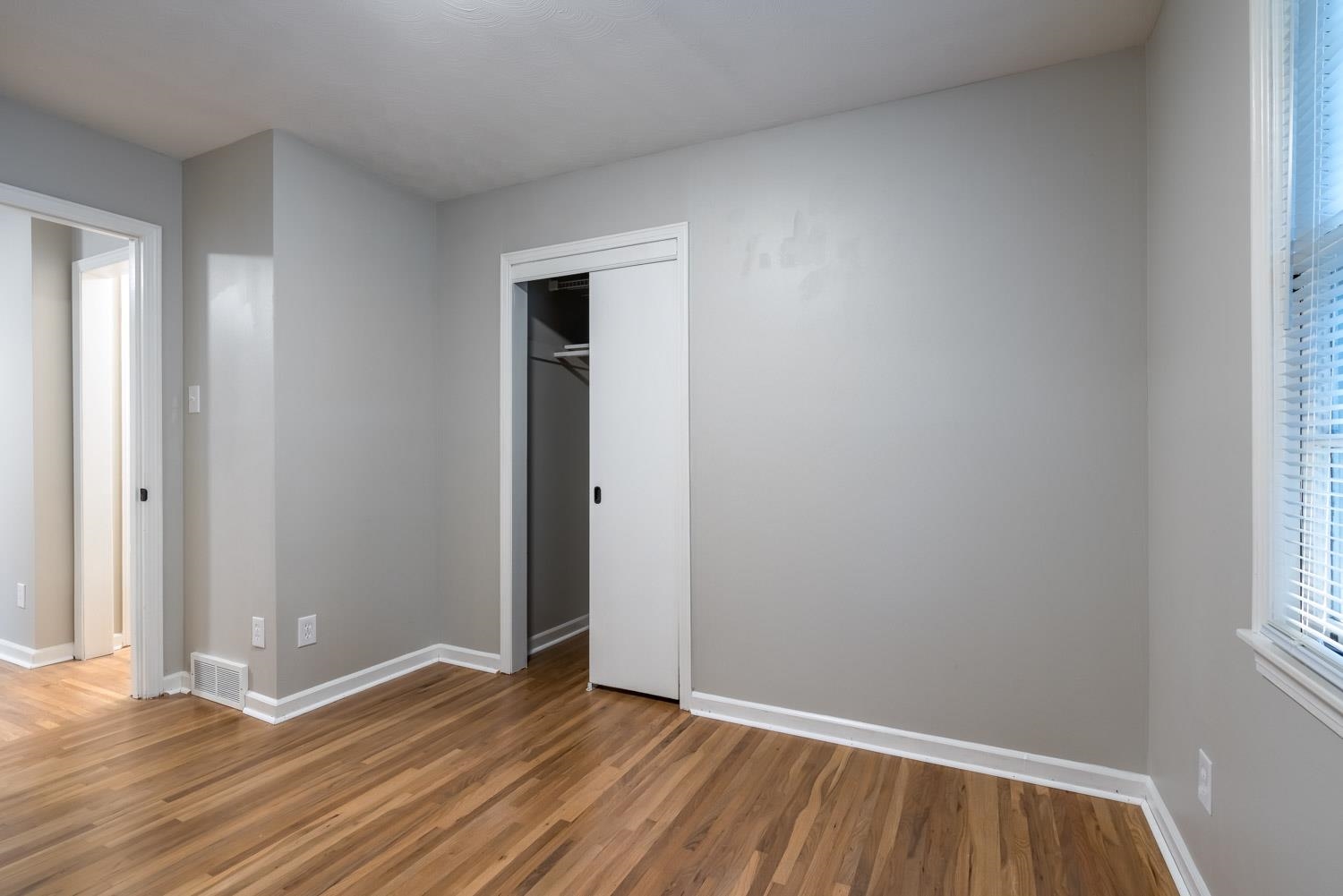 1854 Cherry Road Memphis, TN 38117 - Photo 16 of 25 an empty room with wooden floor and windows