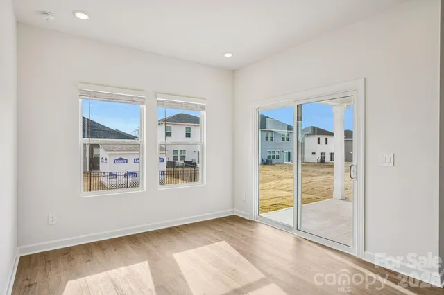 a view of an empty room with window and a bathroom