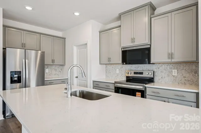 a kitchen with stainless steel appliances a microwave a sink a stove and cabinets