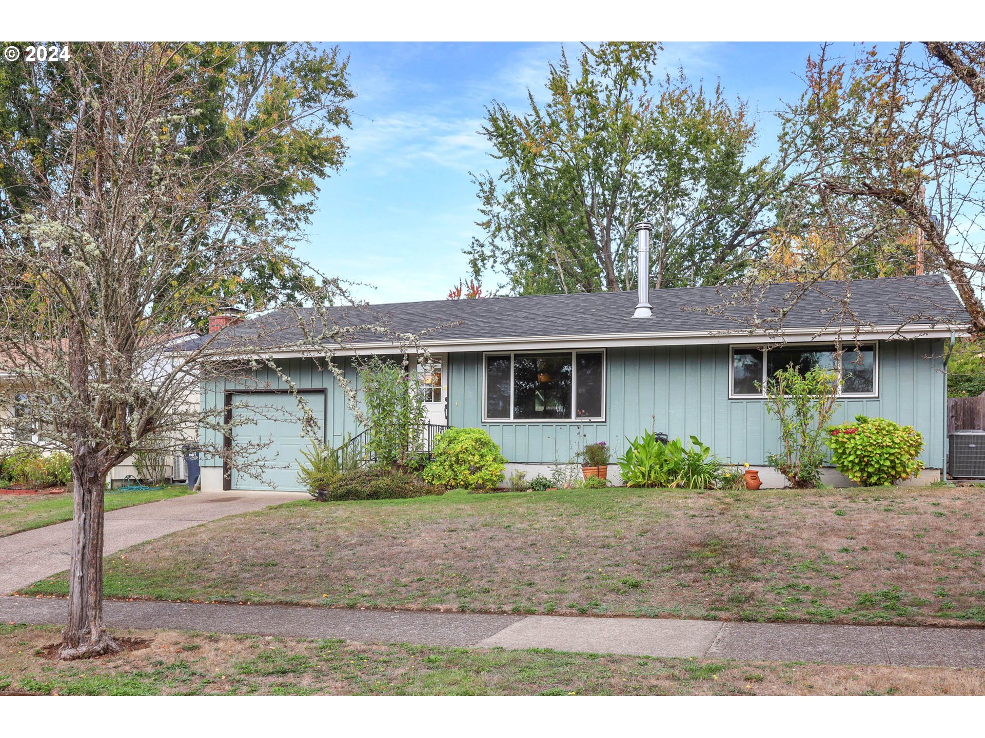 a front view of a house with a yard and potted plants