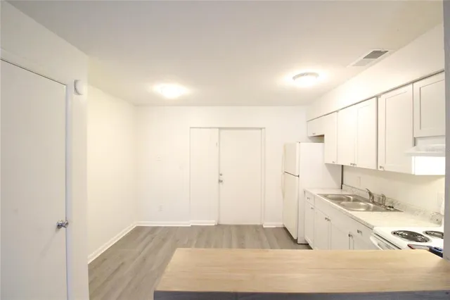a kitchen with white cabinets and white appliances