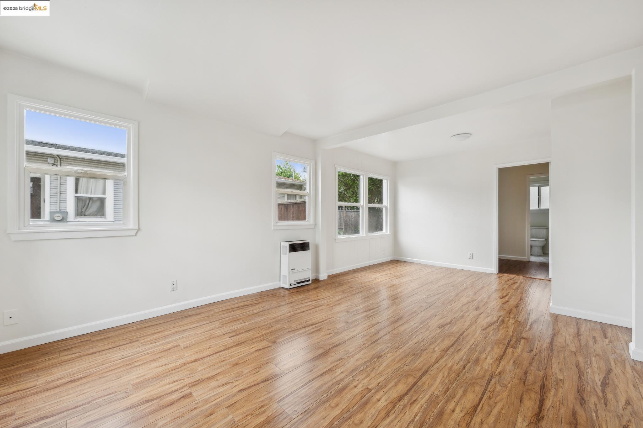 1226 Russell Street Berkeley, CA 94702 - Photo 11 of 32 a view of an empty room with wooden floor and a window