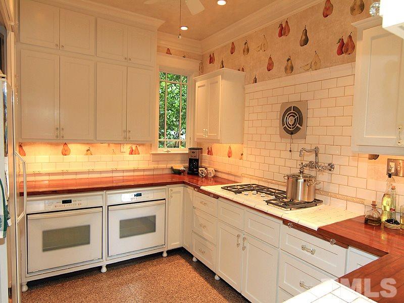 2327 Byrd Street Raleigh, NC 27608 - Photo 9 of 25 a kitchen with stainless steel appliances white cabinets and a stove