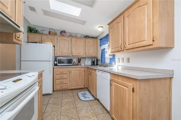 a kitchen with a refrigerator sink and cabinets