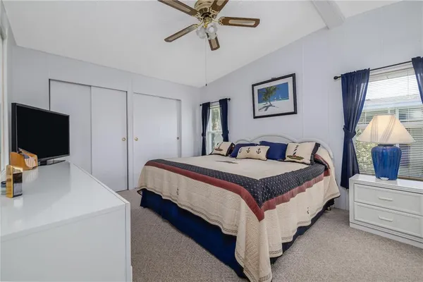 a bedroom with bed and a flat tv screen