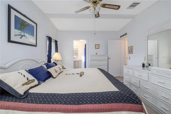 a bed room with a bed a couch and a chandelier