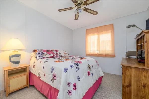 a bedroom with a bed and a flat tv screen on dresser