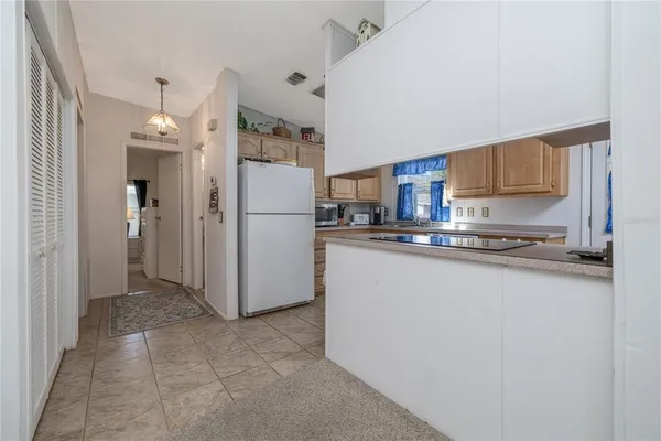 a kitchen with refrigerator and cabinets
