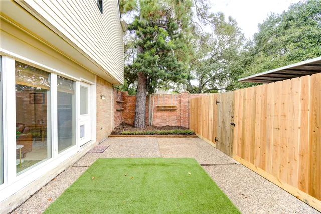 a view of backyard with wooden fence