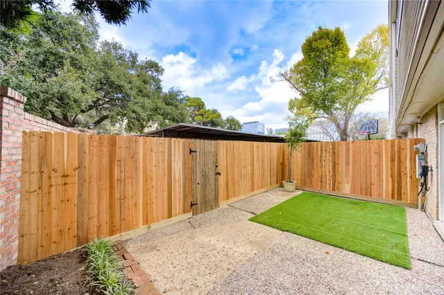 a backyard of a house with lots of green space and wooden fence