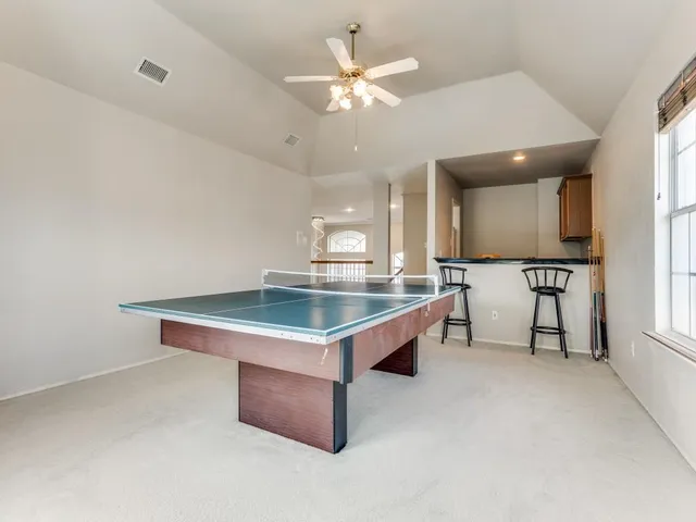 a room with pool table and windows