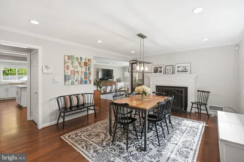 a view of a dining room with furniture a rug and wooden floor