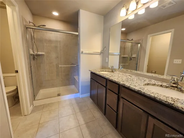 a bathroom with a granite countertop sink mirror and shower
