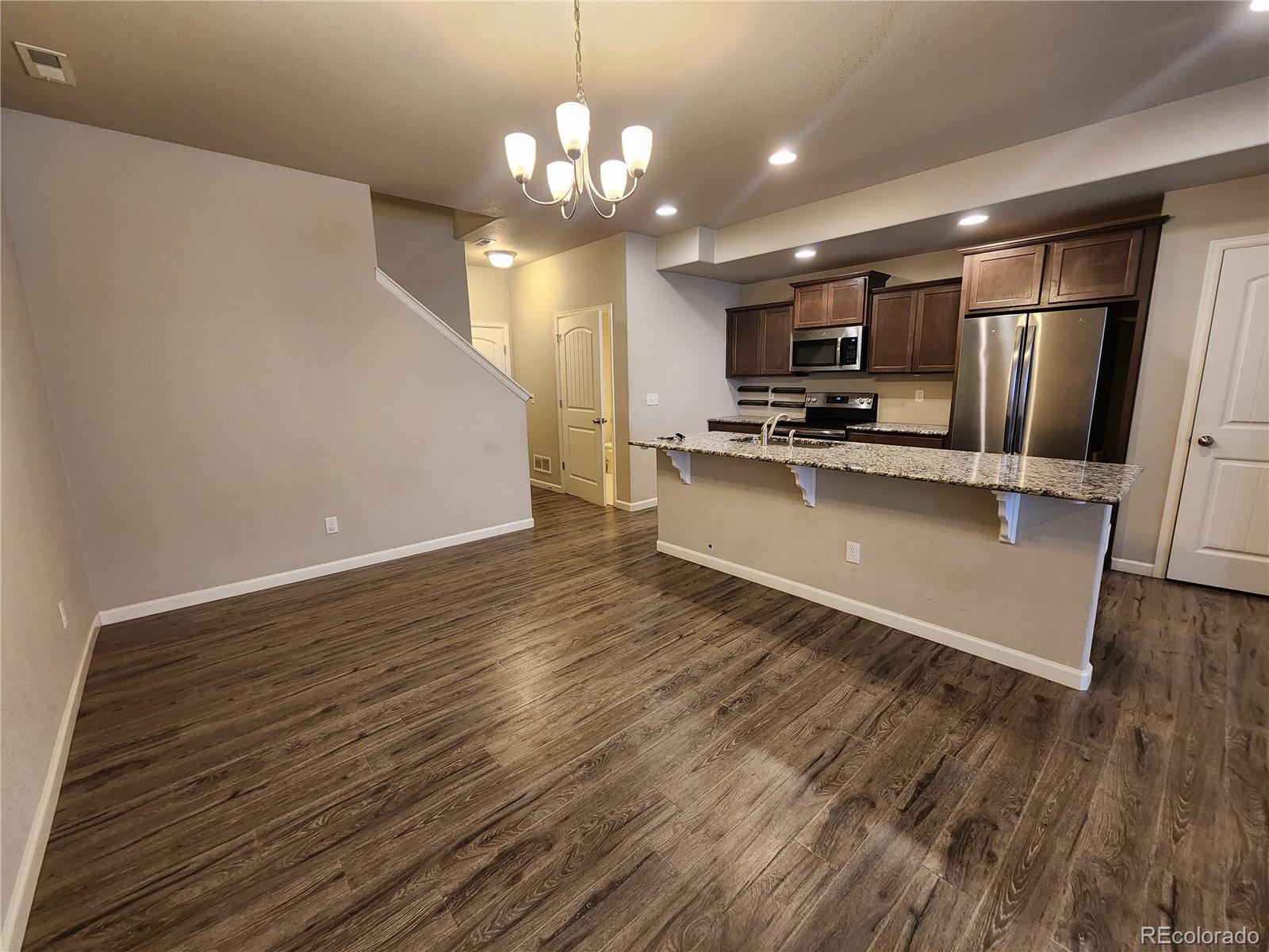 2118 Birmingham Loop Colorado Springs, CO 80910 - Photo 5 of 20 a large kitchen with stainless steel appliances a large counter top a stove and a refrigerator