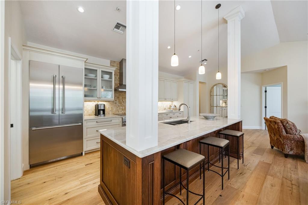 611 10th Avenue South, Unit B2 Naples, FL 34102 - Photo 13 of 27 Kitchen with glass insert cabinets, built in refrigerator, light wood-style floors, hanging light fixtures, and recessed lighting