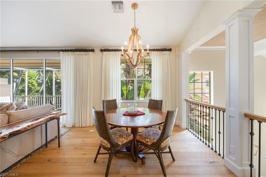 611 10th Avenue South, Unit B2 Naples, FL 34102 - Photo 14 of 27 Dining room with light wood-style floors, a chandelier, and plenty of natural light
