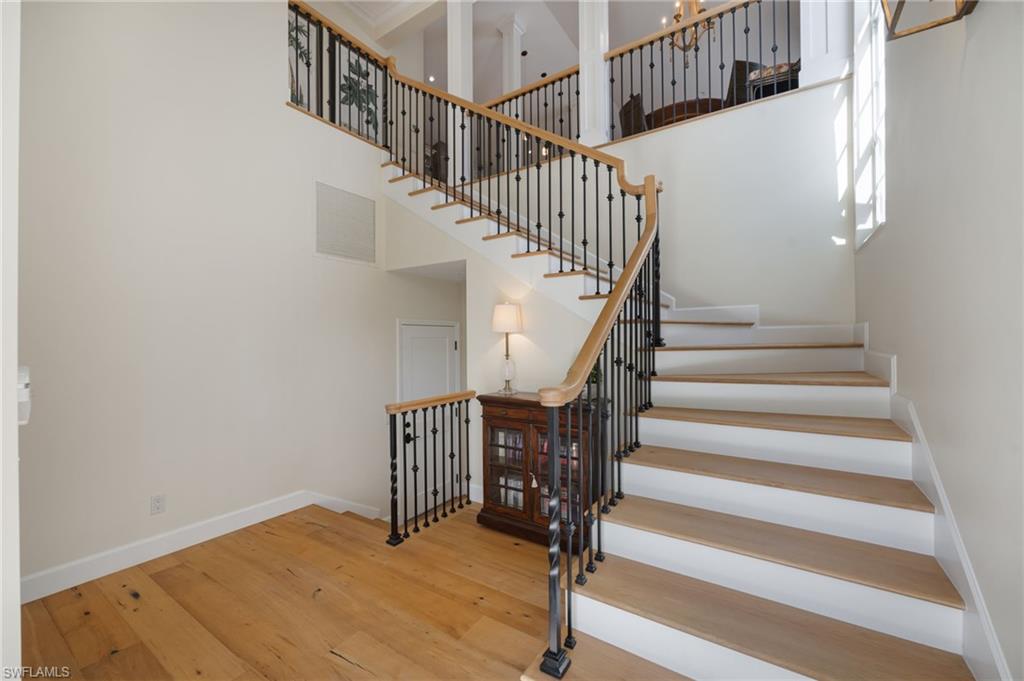 611 10th Avenue South, Unit B2 Naples, FL 34102 - Photo 4 of 27 Staircase featuring hardwood / wood-style flooring and a high ceiling