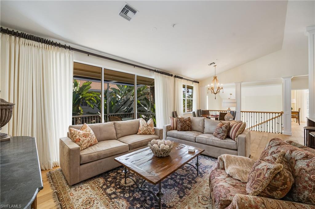 611 10th Avenue South, Unit B2 Naples, FL 34102 - Photo 6 of 27 Living area featuring lofted ceiling, wood finished floors, and a chandelier