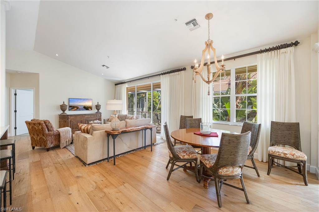 611 10th Avenue South, Unit B2 Naples, FL 34102 - Photo 9 of 27 Dining space featuring light wood-style floors, a chandelier, and lofted ceiling