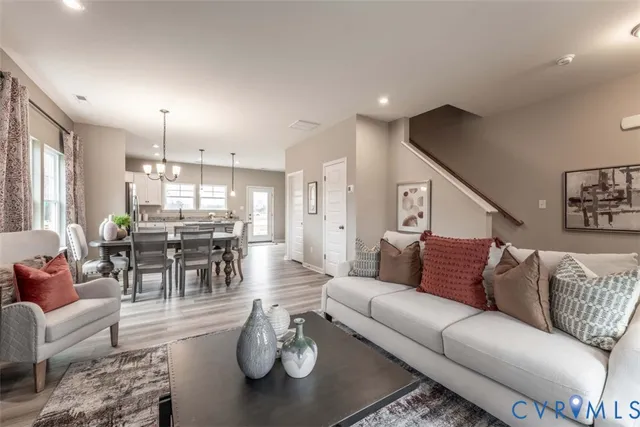 a living room with furniture kitchen and a chandelier