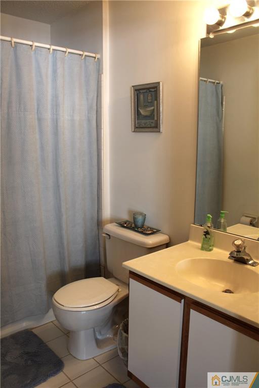 98 Prestwick Way Edison, NJ 08820 - Photo 11 of 16 a bathroom with a sink a toilet and shower curtain