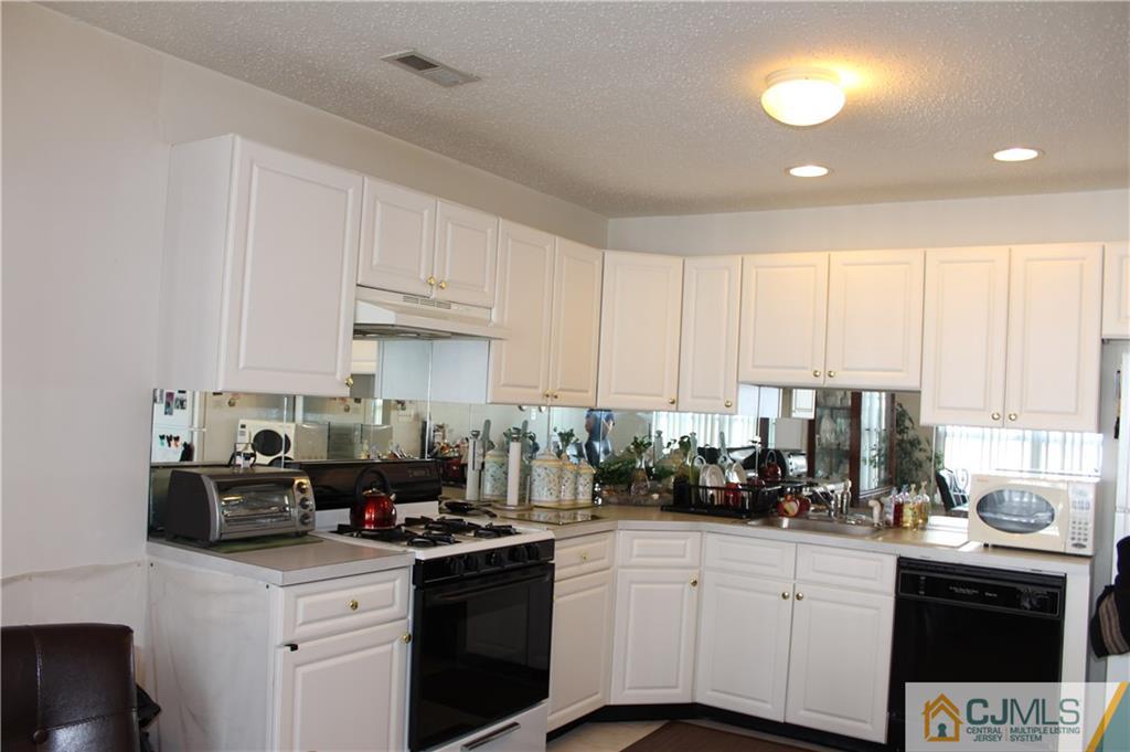 98 Prestwick Way Edison, NJ 08820 - Photo 3 of 16 a kitchen with stainless steel appliances granite countertop a sink stove and cabinets