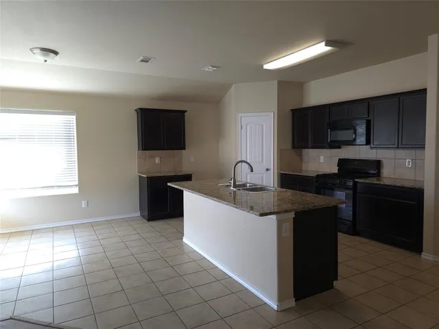 a kitchen with a sink a counter top space cabinets and stainless steel appliances