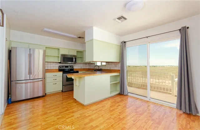 a kitchen with a refrigerator a stove top oven a sink and a large window