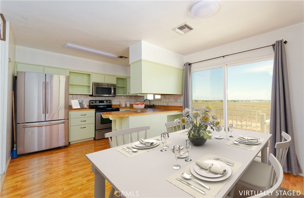 5501 Colorado River Road Blythe, CA 92225 - Photo 16 of 45 a kitchen with stainless steel appliances granite countertop a stove a refrigerator a sink dishwasher a dining table and chairs with wooden floor