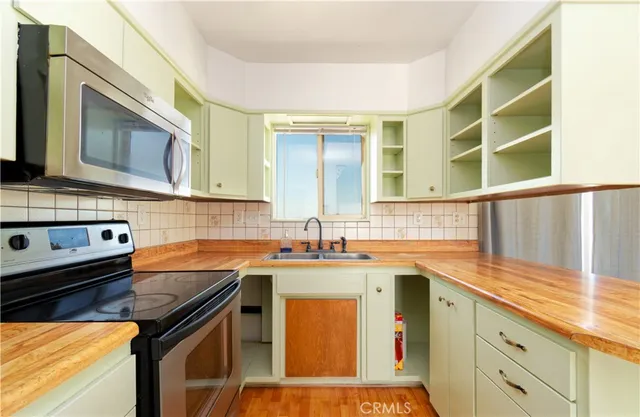 a kitchen with stainless steel appliances granite countertop a sink stove and cabinets