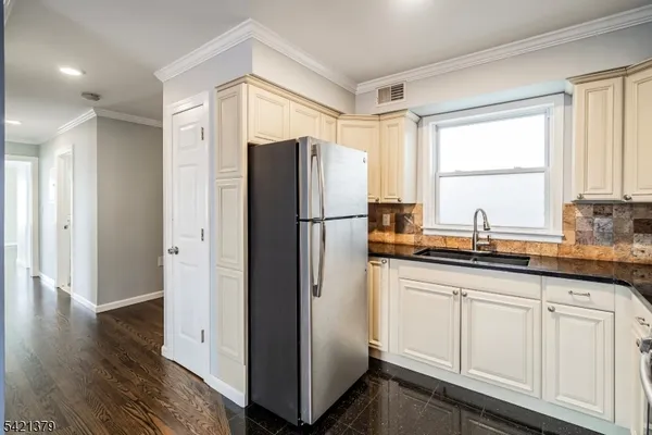 a kitchen with stainless steel appliances granite countertop a refrigerator and a sink
