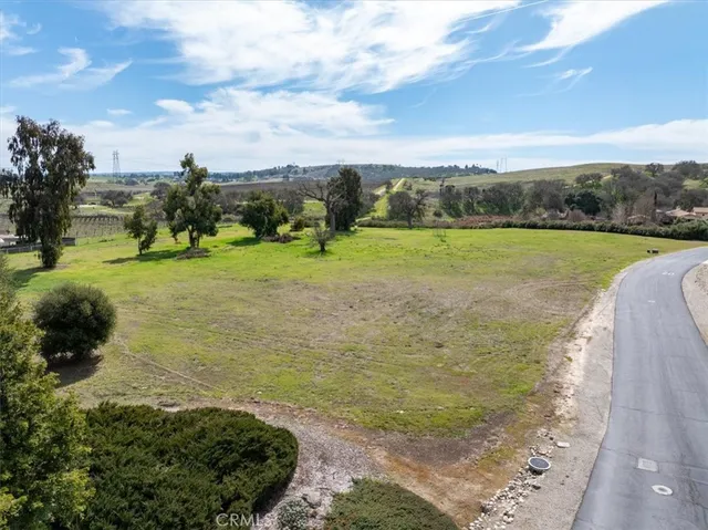 a view of a field with an trees in front of it