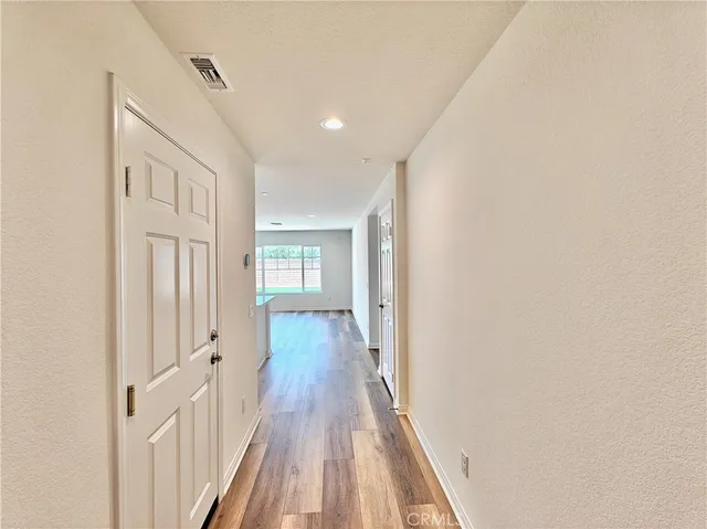 a view of a hallway with wooden floor and entryway