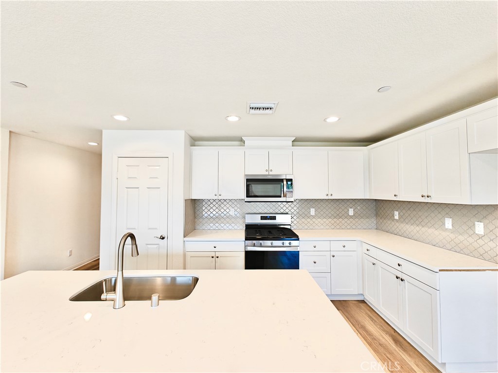 20055 Lemonscent Drive Riverside, CA 92507 - Photo 5 of 19 a kitchen with kitchen island a sink stainless steel appliances and cabinets
